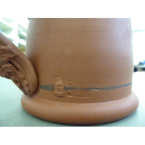 124 - A David Birch Pulman Pottery terracotta mug with a moulded loop handle and Royal Commemorative medal... 