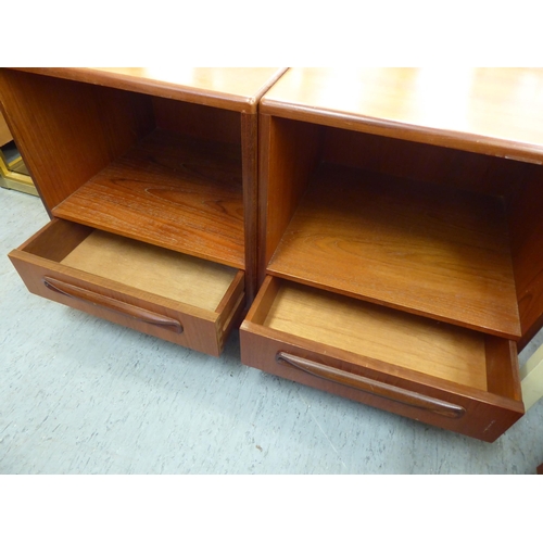 150 - A pair of G-Plan teak bedside cabinets, each with an open shelf and single drawer, on a plinth ... 