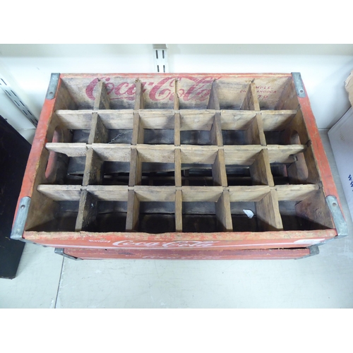 172 - A pair of red stained pine Coco-Cola bottle trays with iron re-enforcement and twenty-four apertures... 