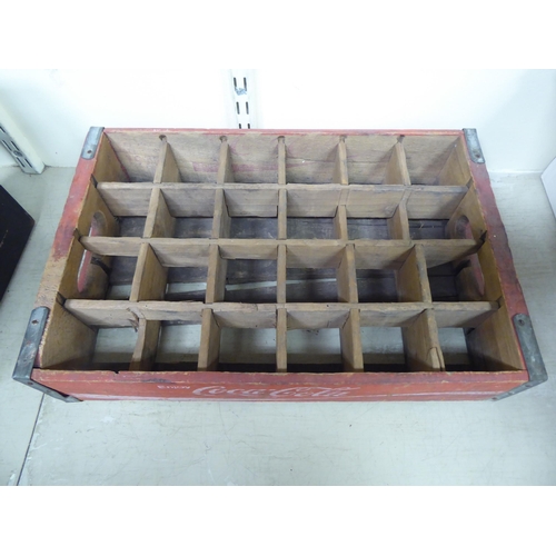 172 - A pair of red stained pine Coco-Cola bottle trays with iron re-enforcement and twenty-four apertures... 