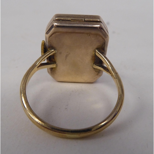 173 - A lady's gold coloured metal cased ring watch, faced by an Arabic dial