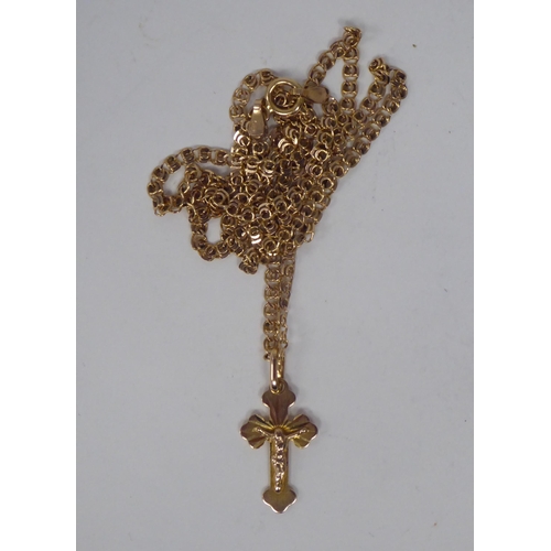 175 - A 14ct gold pendant crucifix, on a fine fancy link neckchain and ring-bolt clasp 