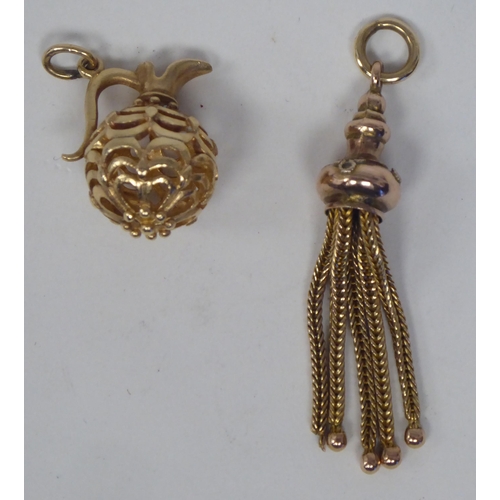 183 - Two gold coloured metal charms, viz. a miniature ewer; and a tasselled pendant