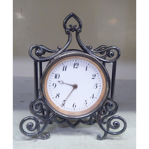 192 - A late Victorian silver cased mantel timepiece of drum design, in an ornately scrolled wire frame; t... 