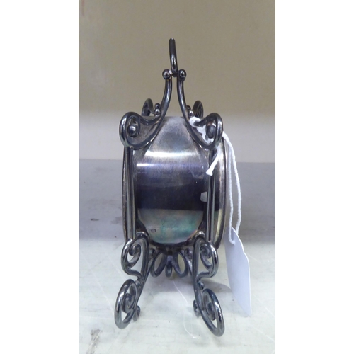 192 - A late Victorian silver cased mantel timepiece of drum design, in an ornately scrolled wire frame; t... 