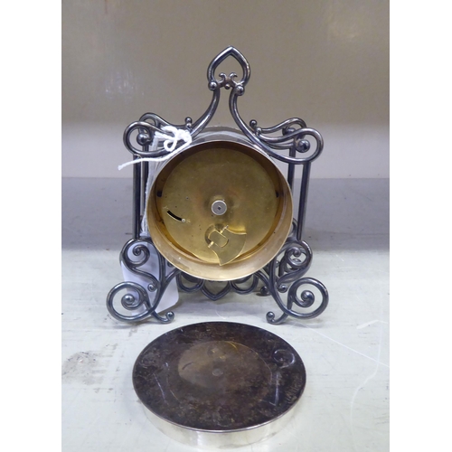 192 - A late Victorian silver cased mantel timepiece of drum design, in an ornately scrolled wire frame; t... 