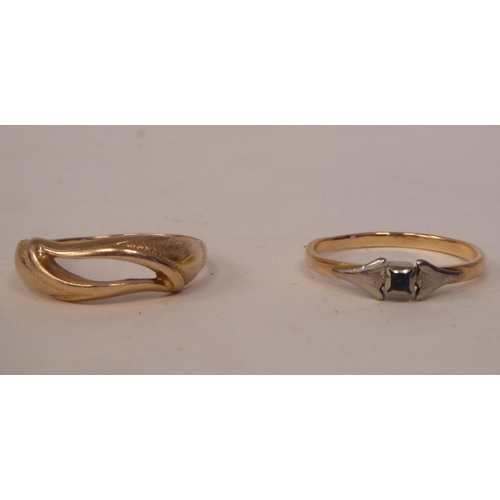 193 - A yellow metal ring of flowing design; and another, set with a single coloured stone