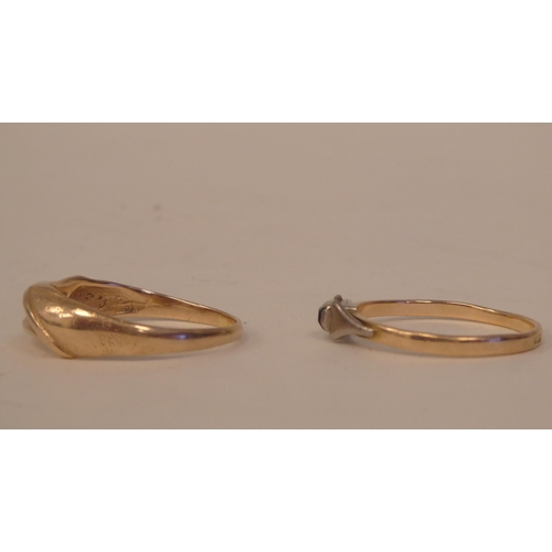 193 - A yellow metal ring of flowing design; and another, set with a single coloured stone