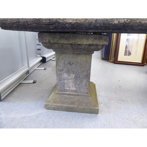 203 - A three part composition stone garden bench, raised on block pedestals  52