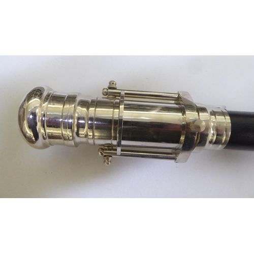 205 - An ebonised walking stick, the chromium plated handle incorporating a telescope