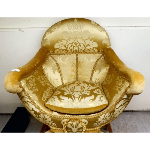 22 - An early 20thC Savonarola inspired chair, upholstered in old gold coloured floral patterned fabric