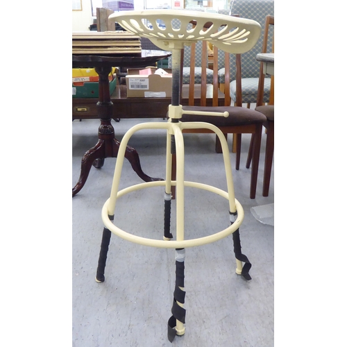 224 - A cream painted cast metal tractor seat design bar stool