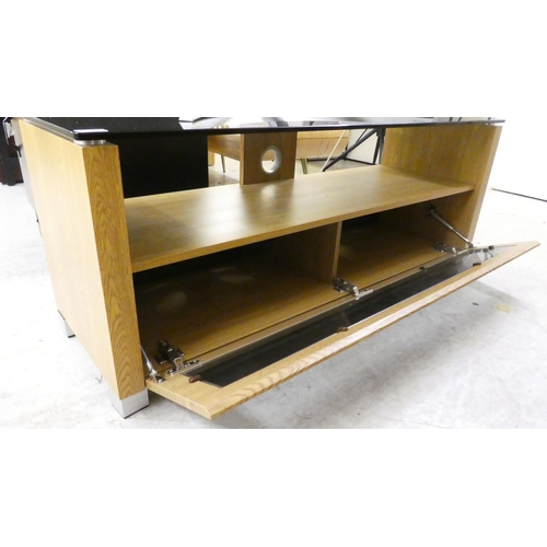 23 - A modern laminated light oak effect and tinted glass television stand  19