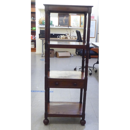 282 - A George III mahogany four tier what-not, on ring turned supports, incorporating a hinged top and a ... 