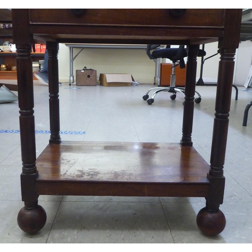 282 - A George III mahogany four tier what-not, on ring turned supports, incorporating a hinged top and a ... 