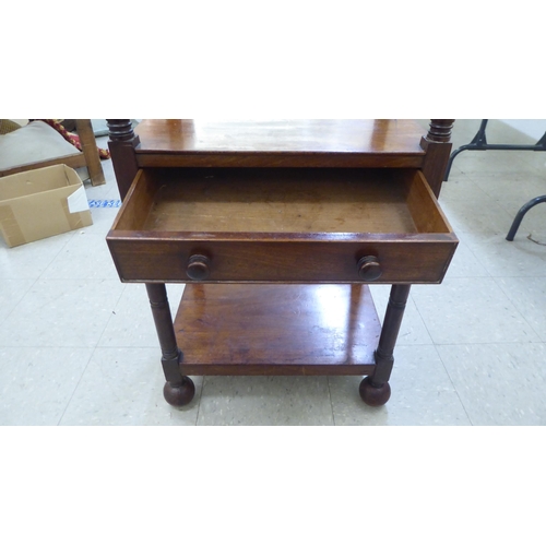 282 - A George III mahogany four tier what-not, on ring turned supports, incorporating a hinged top and a ... 