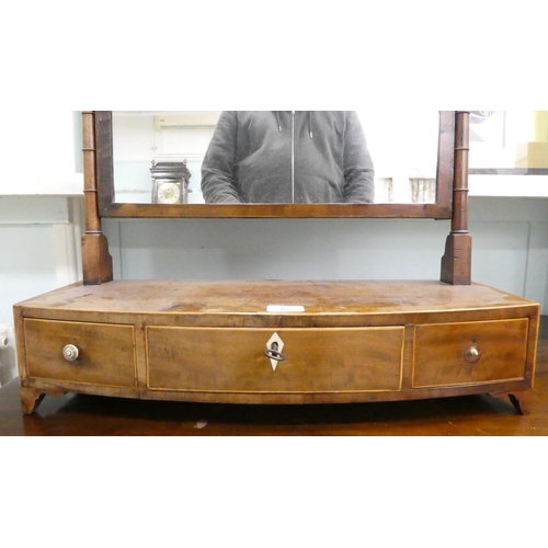 62 - A Regency mahogany toilet mirror, pivoting on turned horns, on a box base with three drawers  25