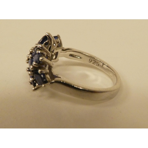 71 - A white metal cluster ring, set with oval cut sapphires  stamped 925