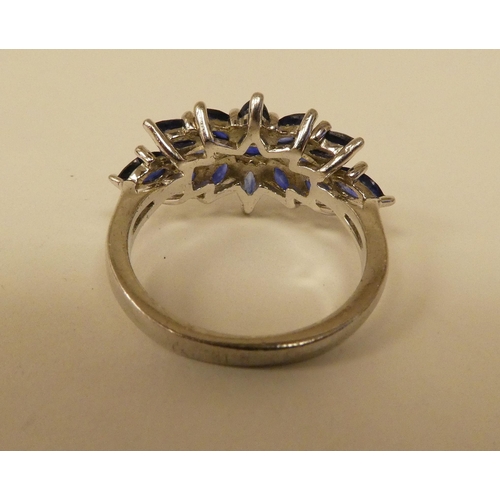 71 - A white metal cluster ring, set with oval cut sapphires  stamped 925