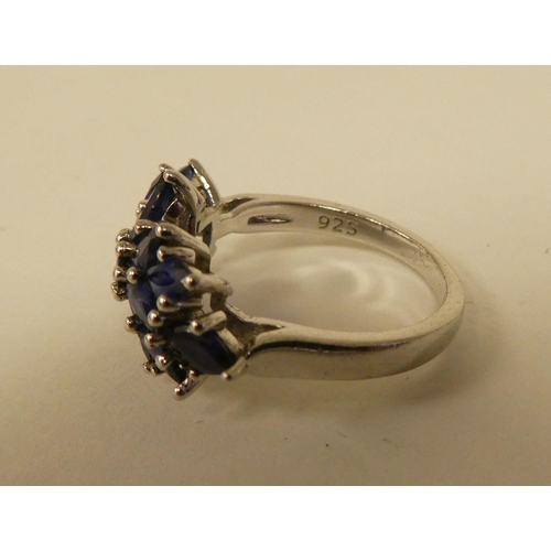 71 - A white metal cluster ring, set with oval cut sapphires  stamped 925