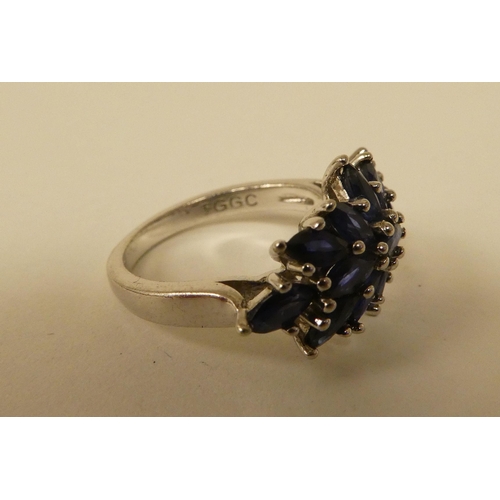 71 - A white metal cluster ring, set with oval cut sapphires  stamped 925
