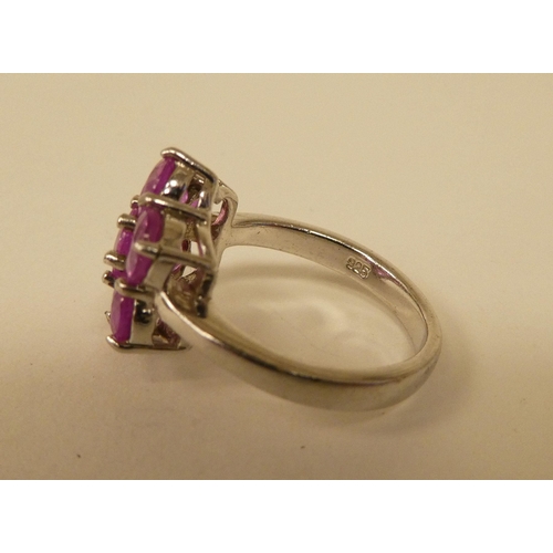 91 - A white metal cluster ring, set with seven pink sapphires  stamped 925