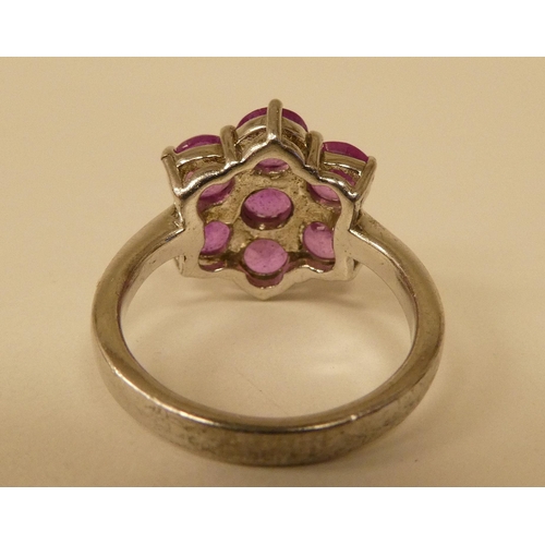 91 - A white metal cluster ring, set with seven pink sapphires  stamped 925