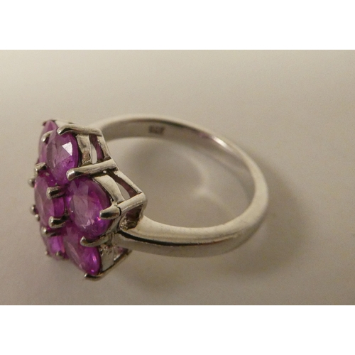 91 - A white metal cluster ring, set with seven pink sapphires  stamped 925