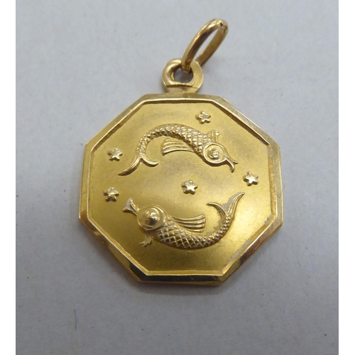 248 - An 18ct gold pendant, decorated with a pair of fish, amidst stars  stamped 750