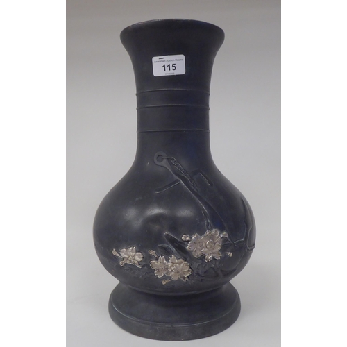 115 - A 19thC Japanese Meiji period bronze bottle vase with a narrow neck and flared rim, decorated in par... 