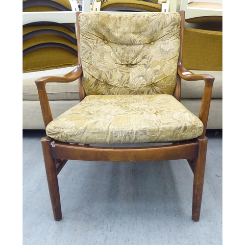 166 - A vintage Parker Knoll, stained beech framed fireside armchair, raised on turned legs and stretchers