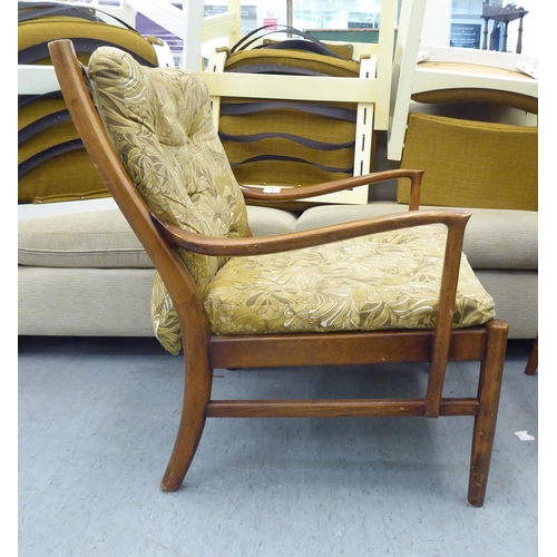 166 - A vintage Parker Knoll, stained beech framed fireside armchair, raised on turned legs and stretchers