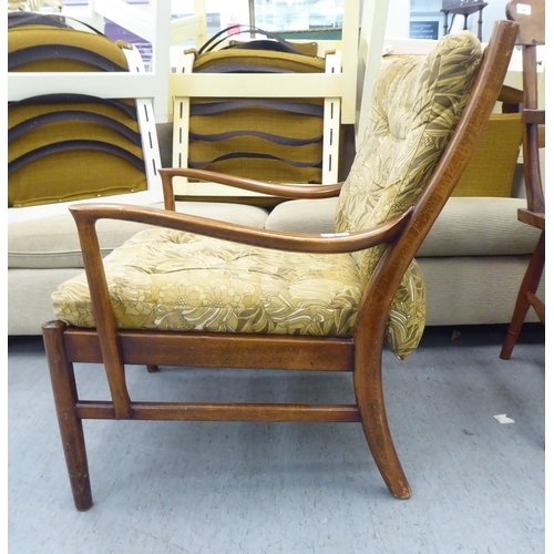 166 - A vintage Parker Knoll, stained beech framed fireside armchair, raised on turned legs and stretchers