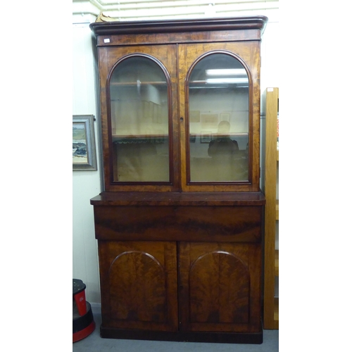 169 - A mid Victorian mahogany cabinet bookcase with a straight cornice, over a pair of glazed doors, encl... 