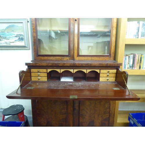 169 - A mid Victorian mahogany cabinet bookcase with a straight cornice, over a pair of glazed doors, encl... 