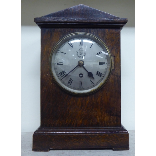 187 - A 1920s oak cased mantel clock; the movement faced by a Roman dial with an RAF emblem  14