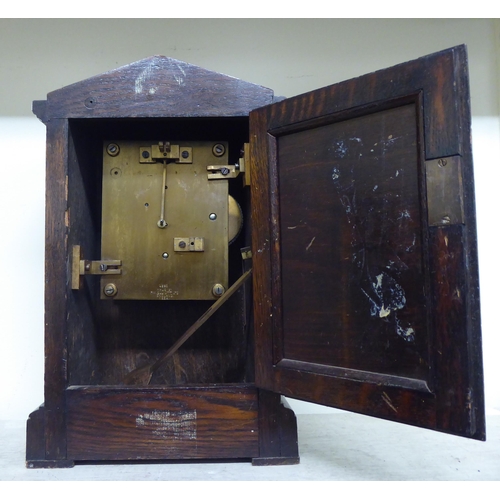 187 - A 1920s oak cased mantel clock; the movement faced by a Roman dial with an RAF emblem  14