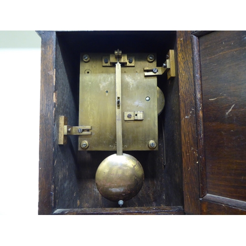 187 - A 1920s oak cased mantel clock; the movement faced by a Roman dial with an RAF emblem  14