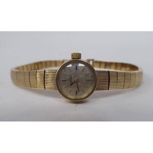 199 - A ladies Omega 9ct gold cased bracelet wristwatch, faced by a baton dial