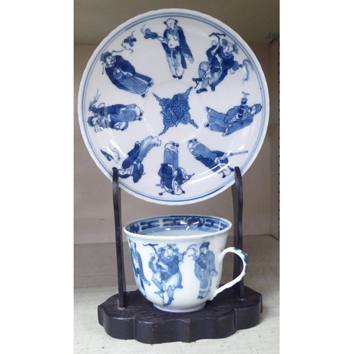 203 - An 18thC Chinese porcelain cup and saucer, decorated with figures, in blue and white, bearing a four... 