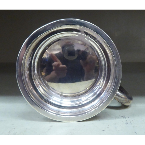 226 - A silver half-pint tankard, on a pedestal foot  Birmingham 1943