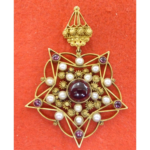 227 - A yellow metal star design pendant, set with garnets and seed pearls