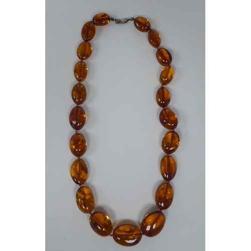 237 - An amber coloured graduated oval bead necklet, the dog-clip clasp stamped 925