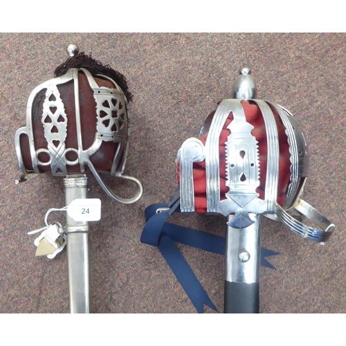 24 - Two similar 18thC style Scottish broadswords with typical basket hilts, the blades 32