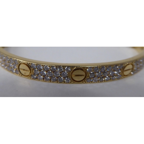 240 - A Cartier style 18ct gold diamond set 'Love' style bangle  stamped 750