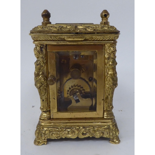 25 - An early/mid 20thC traveller's decoratively cast brass cased carriage timepiece with bevelled glass ... 