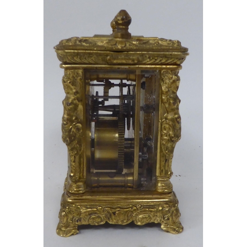 25 - An early/mid 20thC traveller's decoratively cast brass cased carriage timepiece with bevelled glass ... 