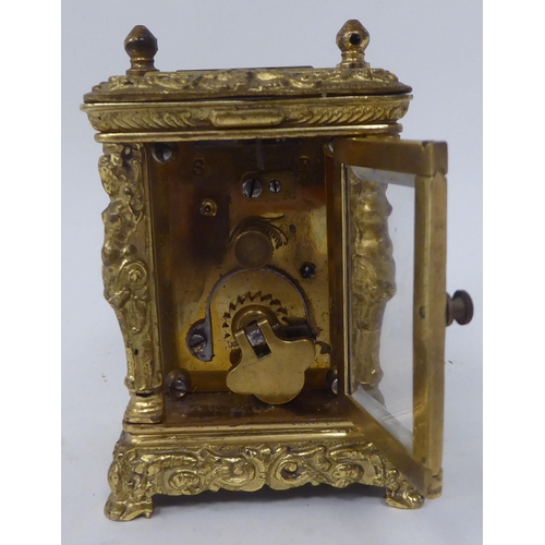 25 - An early/mid 20thC traveller's decoratively cast brass cased carriage timepiece with bevelled glass ... 