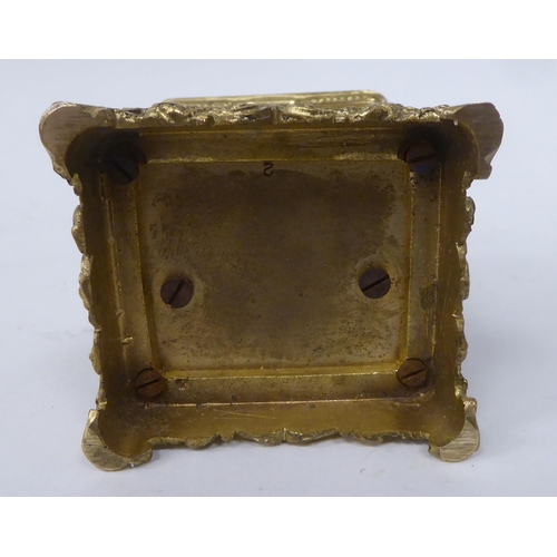 25 - An early/mid 20thC traveller's decoratively cast brass cased carriage timepiece with bevelled glass ... 