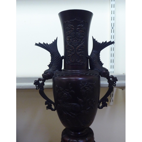 253 - A modern Japanese two-part bronze, twin handled, ornately cast vase, decorated in relief with grotes... 